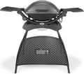 Weber Q2400 Barbecue elettrico con supporto + tavolini laterali, superficie di cottura 54 x 39 cm, portatile, griglia di cottura in ghisa smaltata in due pezzi, coperchio e braciere in ghisa d'alluminio - Grigio scuro (55020879)